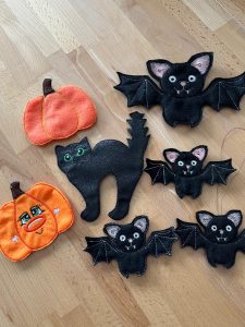 Dekorationen für Halloween: Kürbisse, Fledermäuse und eine schwarze Katze